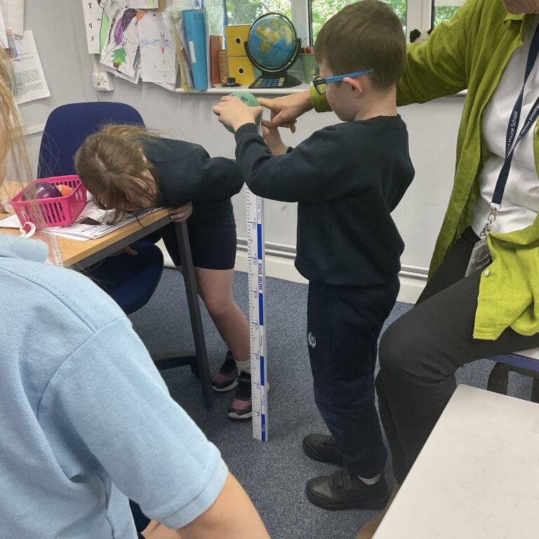 boy holding up a giant ruler
