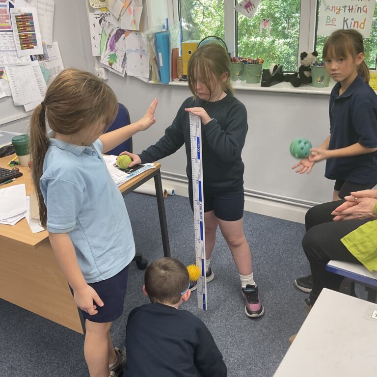 school kids holding a giant ruler